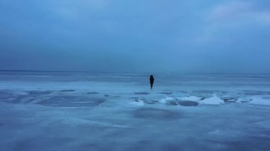Göl, donmuş gölde yürüyen kız donmuş bir gölün buzunda yürüyen kız, İzlanda 'da elmas plajı boyunca yürüyen kadın. Ayaklar buzda, kız donmuş gölde yürüyor. 