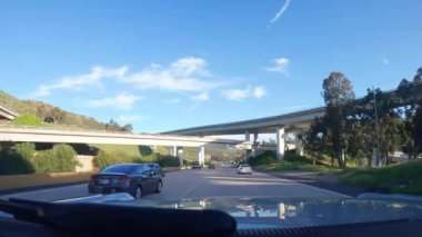 Los Angeles, California USA - 08 18 2023: Kaliforniya 'da şehirlerarası otoyolda araba sürmek. Arabanın ön camından dışarı odaklanmış görüntü. Bulanık banliyö yolu. Otomatik kameranın içinde 