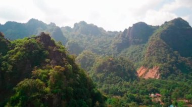 Hava aracı videosu, gün batımında Vietnam 'ın dağları ve pirinç tarlaları. Bereketli yeşil yağmur ormanları şafak vakti sisli dağlarla kaplı Karst Dağları Kedi Ba Adası, Halong Körfezi, Vietnam