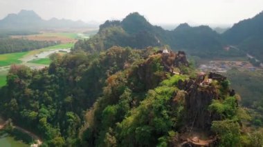 Hava aracı videosu, gün batımında Vietnam 'ın dağları ve pirinç tarlaları. Bereketli yeşil yağmur ormanları şafak vakti sisli dağlarla kaplı Karst Dağları Kedi Ba Adası, Halong Körfezi, Vietnam