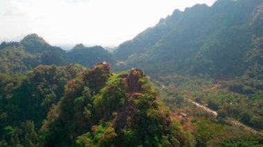 Hava aracı videosu, gün batımında Vietnam 'ın dağları ve pirinç tarlaları. Bereketli yeşil yağmur ormanları şafak vakti sisli dağlarla kaplı Karst Dağları Kedi Ba Adası, Halong Körfezi, Vietnam