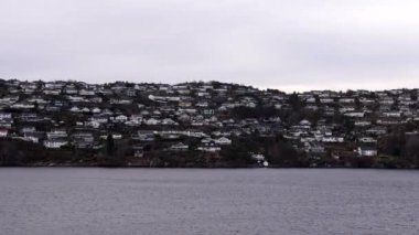 Norveç 'te gezinti. Bottan fiyordun manzarası, tekneden dağların manzarası, şelaleler, yolcu gemileri ve hassas tekneler turistleri gemiden kıyıya taşıyan mavi gökyüzü ile güzel bir günde