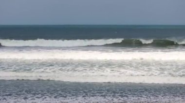 Endonezya, Bali 'de kara plaj. Kum geçmişi. Yaz deniz manzarası, Bali, Endonezya 'da siyah plajlı deniz ve tropikal ada manzarası, yaz manzarası, gün batımında kumsal manzarası.