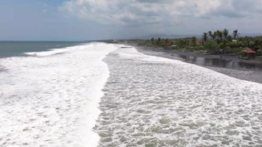 Endonezya, Bali 'de kara plaj. Kum geçmişi. Yaz deniz manzarası, Bali, Endonezya 'da siyah plajlı deniz ve tropikal ada manzarası, yaz manzarası, gün batımında kumsal manzarası.