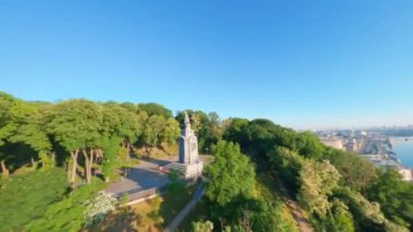 FPV drone, Reunion Arch, Kyiv: Halkın Dostluk Kemeri ve Volodymyr Hill Köprüsü. Kiev 'deki parkın ve yaya köprüsünün manzarası. Parktaki insanlar ve yeşil ağaçlar. Drone Video. Ukrayna. Avrupa