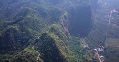 Hava aracı videosu, gün batımında Vietnam 'ın dağları ve pirinç tarlaları. Bereketli yeşil yağmur ormanları şafak vakti sisli dağlarla kaplı Karst Dağları Kedi Ba Adası, Halong Körfezi, Vietnam