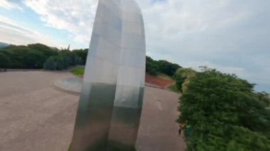KIEV, Ukrayna - 19 Nisan 2021: FPV drone, Reunion Arch, Kyiv: Halkların Dostluk Kemeri ve Volodymyr Tepesi köprüsü. Kiev 'deki parkın ve yaya köprüsünün manzarası. Parktaki insanlar ve yeşil ağaçlar. 