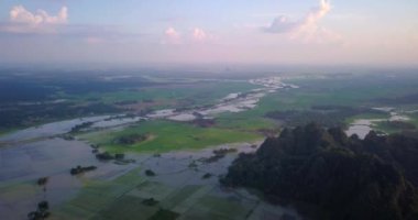 Hava aracı videosu, gün batımında Vietnam 'ın dağları ve pirinç tarlaları. Bereketli yeşil yağmur ormanları şafak vakti sisli dağlarla kaplı Karst Dağları Kedi Ba Adası, Halong Körfezi, Vietnam