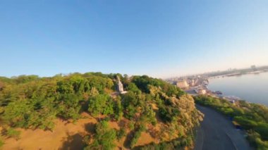 KIEV, Ukrayna - 19 Nisan 2021: FPV drone, Reunion Arch, Kyiv: Halkların Dostluk Kemeri ve Volodymyr Tepesi köprüsü. Kiev 'deki parkın ve yaya köprüsünün manzarası. Parktaki insanlar ve yeşil ağaçlar. 