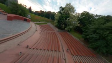 KIEV, Ukrayna - 19 Nisan 2021: FPV drone, Reunion Arch, Kyiv: Halkların Dostluk Kemeri ve Volodymyr Tepesi köprüsü. Kiev 'deki parkın ve yaya köprüsünün manzarası. Parktaki insanlar ve yeşil ağaçlar. 