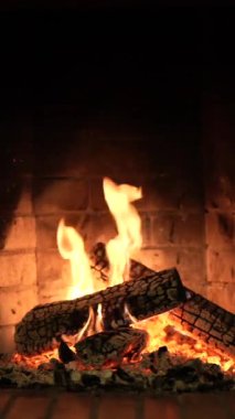 Şömine. Rahatlatıcı Şömine. Yakacak odun. Bir kır evinin alevleri. Sıcaklık ve ev konforu. Toprak. Şöminede ateş yanıyor. Şöminede güzel bir ateş, yanan bir odun. 