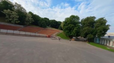 KIEV, Ukrayna - 19 Nisan 2021: FPV drone, Reunion Arch, Kyiv: Halkların Dostluk Kemeri ve Volodymyr Tepesi köprüsü. Kiev 'deki parkın ve yaya köprüsünün manzarası. Parktaki insanlar ve yeşil ağaçlar. 