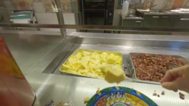 Bir adam otel restoranında yemek seçer. Bir kadın açık büfeden yemek alır. Aperatifli masa, yemek parmakları, salam, peynir, peynir, peynir, hepsi dahil, lezzetli yemekler, lüks atıştırmalıklar, aperatifler