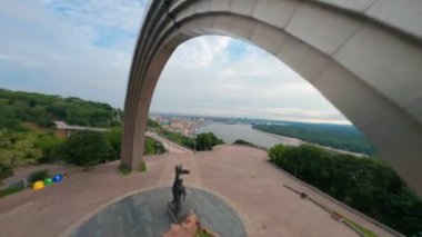 KIEV, Ukrayna - 19 Nisan 2021: FPV drone, Reunion Arch, Kyiv: Halkların Dostluk Kemeri ve Volodymyr Tepesi köprüsü. Kiev 'deki parkın ve yaya köprüsünün manzarası. Parktaki insanlar ve yeşil ağaçlar. 