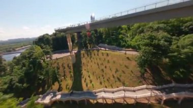 KIEV, Ukrayna - 19 Nisan 2021: FPV drone, Reunion Arch, Kyiv: Halkların Dostluk Kemeri ve Volodymyr Tepesi köprüsü. Kiev 'deki parkın ve yaya köprüsünün manzarası. Parktaki insanlar ve yeşil ağaçlar. 
