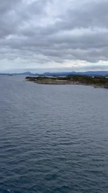Norveç 'te gezinti. Bottan fiyordun manzarası, tekneden dağların manzarası, şelaleler, yolcu gemileri ve hassas tekneler turistleri gemiden kıyıya taşıyan mavi gökyüzü ile güzel bir günde