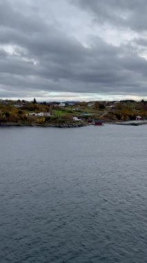 Norveç 'te gezinti. Bottan fiyordun manzarası, tekneden dağların manzarası, şelaleler, yolcu gemileri ve hassas tekneler turistleri gemiden kıyıya taşıyan mavi gökyüzü ile güzel bir günde