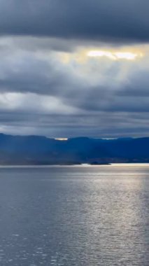Norveç 'te gezinti. Bottan fiyordun manzarası, tekneden dağların manzarası, şelaleler, yolcu gemileri ve hassas tekneler turistleri gemiden kıyıya taşıyan mavi gökyüzü ile güzel bir günde