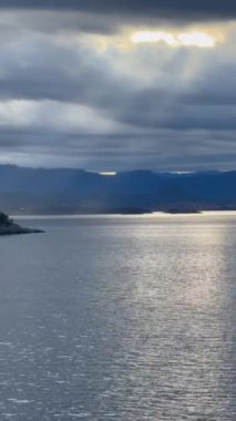 Norveç 'te gezinti. Bottan fiyordun manzarası, tekneden dağların manzarası, şelaleler, yolcu gemileri ve hassas tekneler turistleri gemiden kıyıya taşıyan mavi gökyüzü ile güzel bir günde