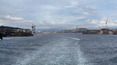 Norveç 'te gezinti. Bottan fiyordun manzarası, tekneden dağların manzarası, şelaleler, yolcu gemileri ve hassas tekneler turistleri gemiden kıyıya taşıyan mavi gökyüzü ile güzel bir günde