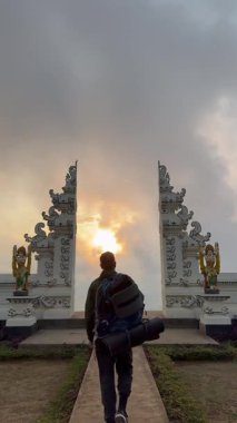 Genç adam doğada aydınlık bir günün tadını çıkarıyor, Bali 'deki Agung volkanına doğru yürüyen adam. 