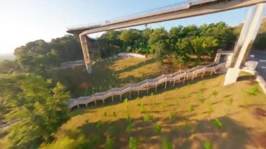 KIEV, Ukrayna - 19 Nisan 2021: FPV drone, Reunion Arch, Kyiv: Halkların Dostluk Kemeri ve Volodymyr Tepesi köprüsü. Kiev 'deki parkın ve yaya köprüsünün manzarası. Parktaki insanlar ve yeşil ağaçlar. 