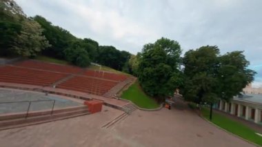 KIEV, Ukrayna - 19 Nisan 2021: FPV drone, Reunion Arch, Kyiv: Halkların Dostluk Kemeri ve Volodymyr Tepesi köprüsü. Kiev 'deki parkın ve yaya köprüsünün manzarası. Parktaki insanlar ve yeşil ağaçlar. 