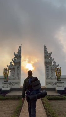 Genç adam doğada aydınlık bir günün tadını çıkarıyor, Bali 'deki Agung volkanına doğru yürüyen adam. 