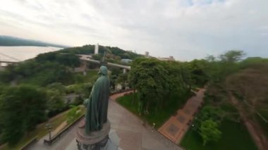 KIEV, Ukrayna - 19 Nisan 2021: FPV drone, Reunion Arch, Kyiv: Halkların Dostluk Kemeri ve Volodymyr Tepesi köprüsü. Kiev 'deki parkın ve yaya köprüsünün manzarası. Parktaki insanlar ve yeşil ağaçlar. 