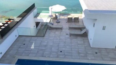 Açık bir pencereden deniz, kıyı şeridi ve Yunanistan 'ın mavi kepenkleri görünüyor.