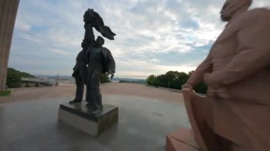 KIEV, Ukrayna - 19 Nisan 2021: FPV drone, Reunion Arch, Kyiv: Halkların Dostluk Kemeri ve Volodymyr Tepesi köprüsü. Kiev 'deki parkın ve yaya köprüsünün manzarası. Parktaki insanlar ve yeşil ağaçlar. 