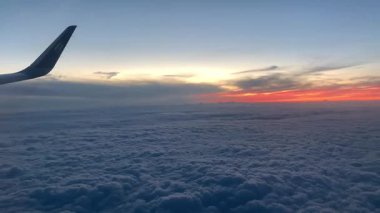 Positano, İtalya - 9 Ağustos 2022: Ufukta güneş yükselirken uçağın penceresinden dışarı bakmak, Bulutlar, manzara 