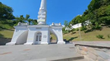 KIEV, Ukrayna - 19 Nisan 2021: FPV drone, Reunion Arch, Kyiv: Halkların Dostluk Kemeri ve Volodymyr Tepesi köprüsü. Kiev 'deki parkın ve yaya köprüsünün manzarası. Parktaki insanlar ve yeşil ağaçlar. 