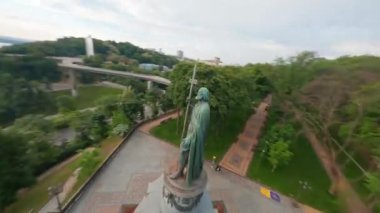 KIEV, Ukrayna - 19 Nisan 2021: FPV drone, Reunion Arch, Kyiv: Halkların Dostluk Kemeri ve Volodymyr Tepesi köprüsü. Kiev 'deki parkın ve yaya köprüsünün manzarası. Parktaki insanlar ve yeşil ağaçlar. 