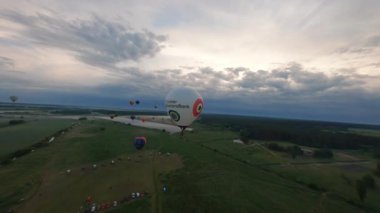 Kyiv, Ukrayna - 05.23.2021: İnsanlarla açık havada sıcak hava balonları. Hava manzaralı arka planda renkli balonlar. Yaz tatili. Sıcak hava balonu sabah uçuyor..