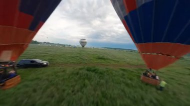 Kyiv, Ukrayna - 05.23.2021: İnsanlarla açık havada sıcak hava balonları. Hava manzaralı arka planda renkli balonlar. Yaz tatili. Sıcak hava balonu sabah uçuyor..