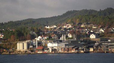 Norveç 'te gezinti. Bottan fiyordun manzarası, tekneden dağların manzarası, şelaleler, yolcu gemileri ve hassas tekneler turistleri gemiden kıyıya taşıyan mavi gökyüzü ile güzel bir günde