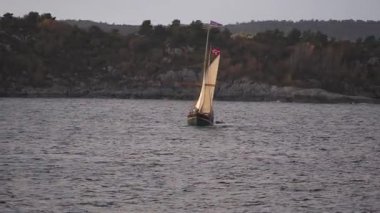 Norveç 'te gezinti. Bottan fiyordun manzarası, tekneden dağların manzarası, şelaleler, yolcu gemileri ve hassas tekneler turistleri gemiden kıyıya taşıyan mavi gökyüzü ile güzel bir günde