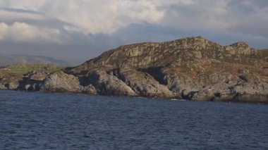 Norveç 'te gezinti. Bottan fiyordun manzarası, tekneden dağların manzarası, şelaleler, yolcu gemileri ve hassas tekneler turistleri gemiden kıyıya taşıyan mavi gökyüzü ile güzel bir günde