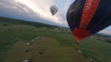 Kyiv, Ukrayna - 05.23.2021: İnsanlarla açık havada sıcak hava balonları. Hava manzaralı arka planda renkli balonlar. Yaz tatili. Sıcak hava balonu sabah uçuyor..