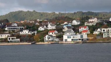Norveç 'te gezinti. Bottan fiyordun manzarası, tekneden dağların manzarası, şelaleler, yolcu gemileri ve hassas tekneler turistleri gemiden kıyıya taşıyan mavi gökyüzü ile güzel bir günde