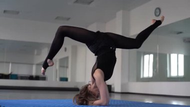  sstkWellness, kız jimnastik yapıyor, jimnastikçi yerde akrobatik bir şey yapıyor. Genç jimnastikçi kız esneme ve antrenman, yoga, esneme, profesyonel spor yapıyor. ritmik 