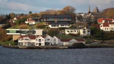 Norveç 'te gezinti. Bottan fiyordun manzarası, tekneden dağların manzarası, şelaleler, yolcu gemileri ve hassas tekneler turistleri gemiden kıyıya taşıyan mavi gökyüzü ile güzel bir günde