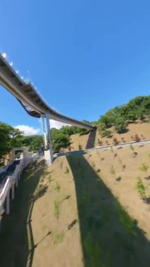 KIEV, Ukrayna - 19 Nisan 2021: FPV drone, Reunion Arch, Kyiv: Halkların Dostluk Kemeri ve Volodymyr Tepesi köprüsü. Kiev 'deki parkın ve yaya köprüsünün manzarası. Parktaki insanlar ve yeşil ağaçlar. 