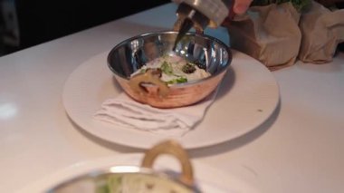 Yemek, yemek ve yaratıcılık için restoranın mutfağında ciddi bir yemek. Erkek çalışan, profesyonel ve aşçılık, konukseverlik ve yemek servisi yapan bir aşçı.