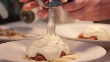 Yemek, yemek ve yaratıcılık için restoranın mutfağında ciddi bir yemek. Erkek çalışan, profesyonel ve aşçılık, konukseverlik ve yemek servisi yapan bir aşçı.