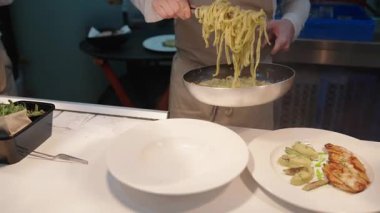 Yemek, yemek ve yaratıcılık için restoranın mutfağında ciddi bir yemek. Erkek çalışan, profesyonel ve aşçılık, konukseverlik ve yemek servisi yapan bir aşçı.