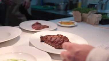 Yemek, yemek ve yaratıcılık için restoranın mutfağında ciddi bir yemek. Erkek çalışan, profesyonel ve aşçılık, konukseverlik ve yemek servisi yapan bir aşçı.