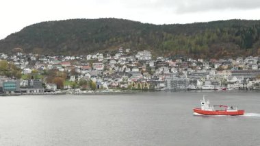 Norveç 'te gezinti. Bottan fiyordun manzarası, tekneden dağların manzarası, şelaleler, yolcu gemileri ve hassas tekneler turistleri gemiden kıyıya taşıyan mavi gökyüzü ile güzel bir günde