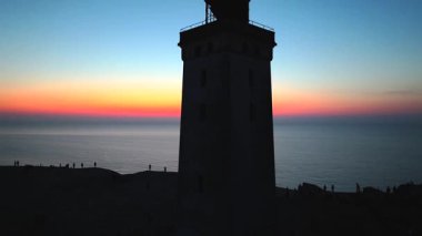 Tepenin tepesinde ünlü deniz feneri olan dev kum tepelerinin hava manzarası. Rubjerg Knude Deniz Feneri, Kuzey Deniz Rubjerg, Danimarka Lokken yakınlarındaki Rubjerg Knude Fyr deniz fenerinde gün batımı. 